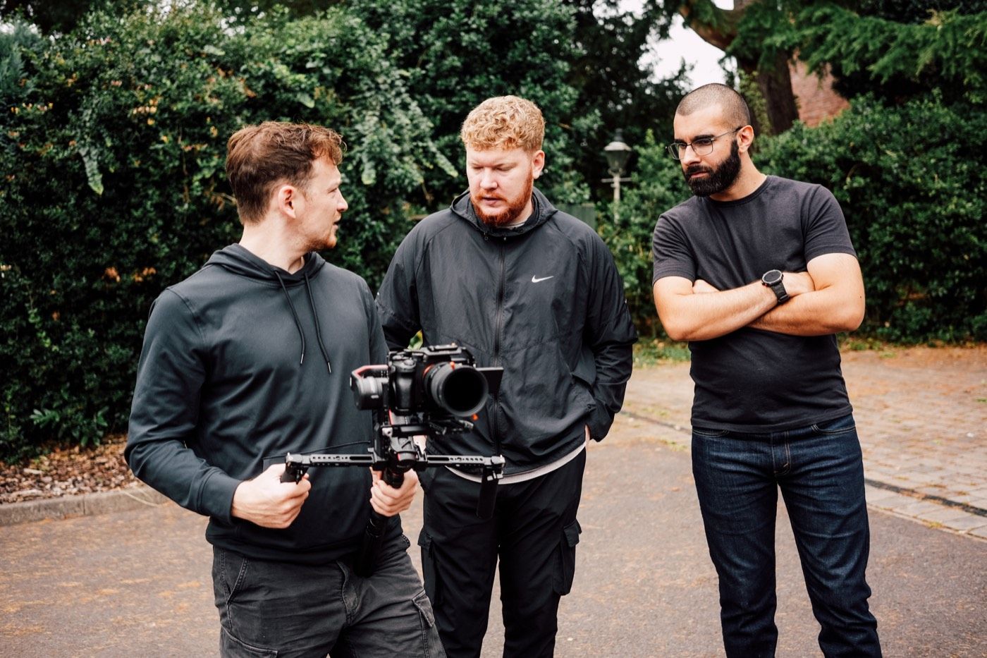 Three of the team on a shoot, one holding a camera on a gimbal