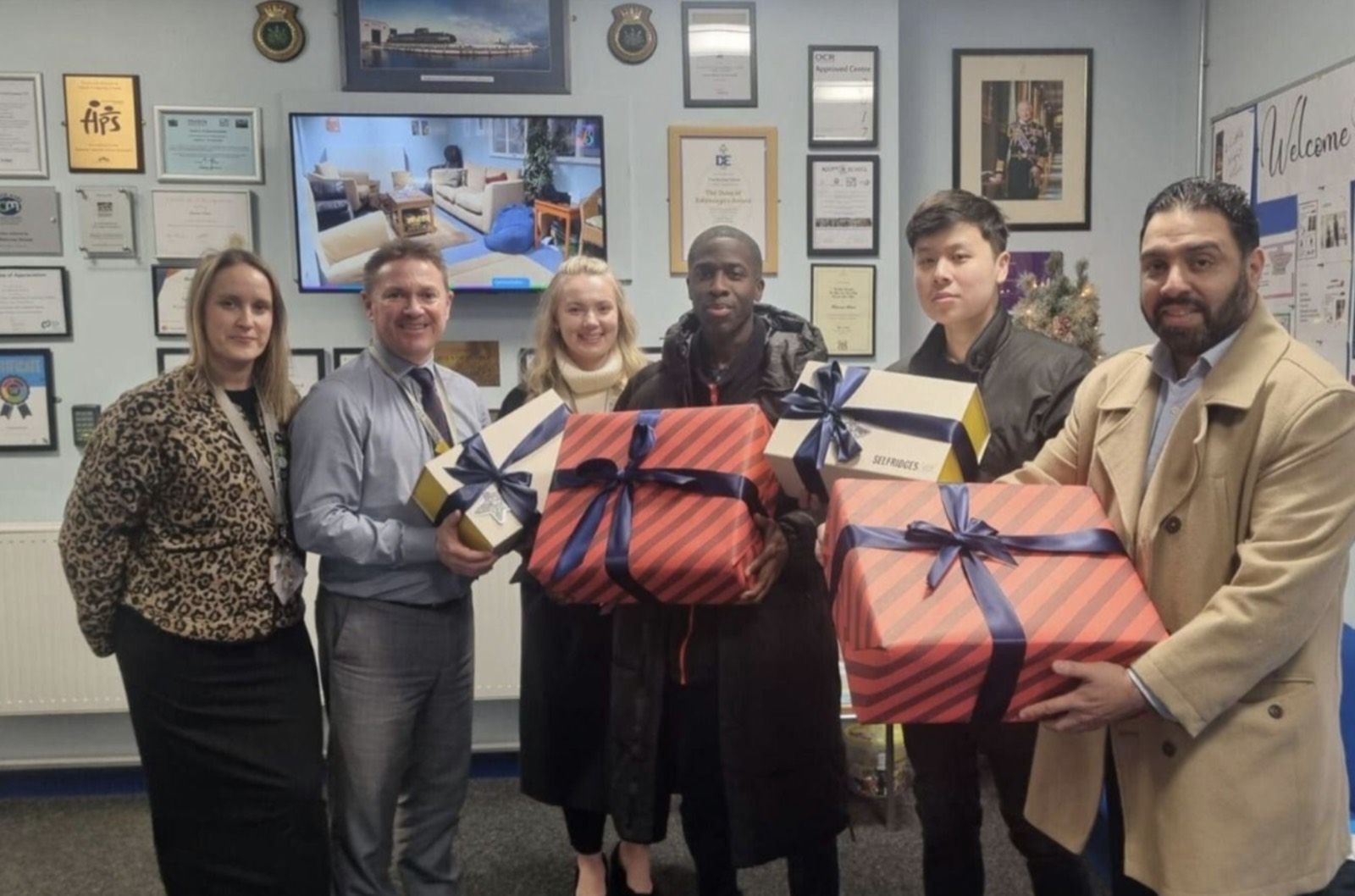 The Ordernised team handing over wrapped gifts at a local school