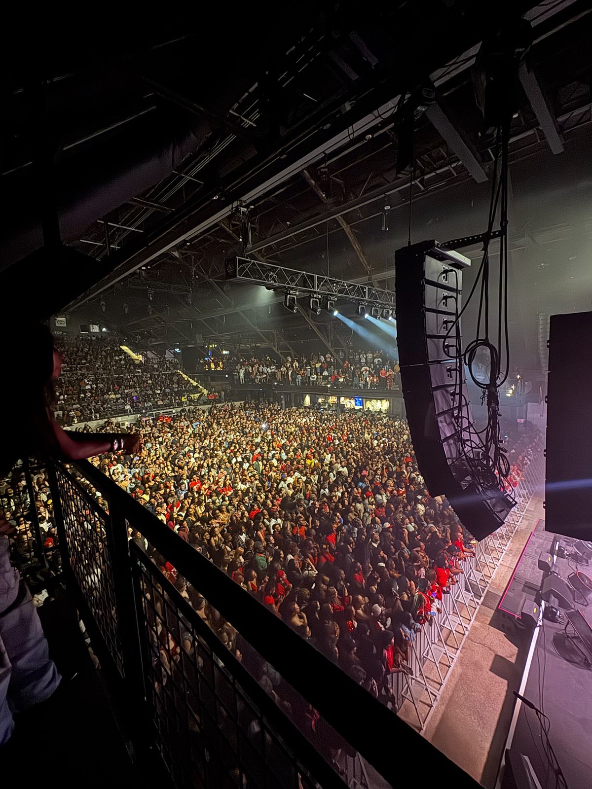A packed arena crowd seen from the balcony