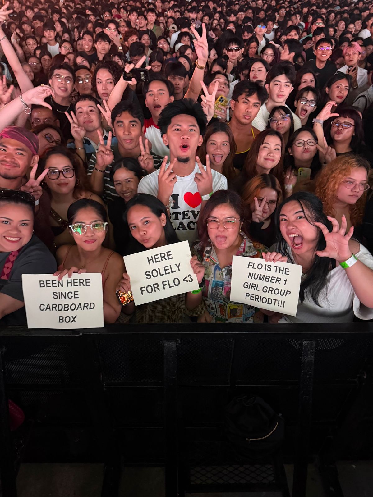 A crowd of fans holding handmade signs for FLO