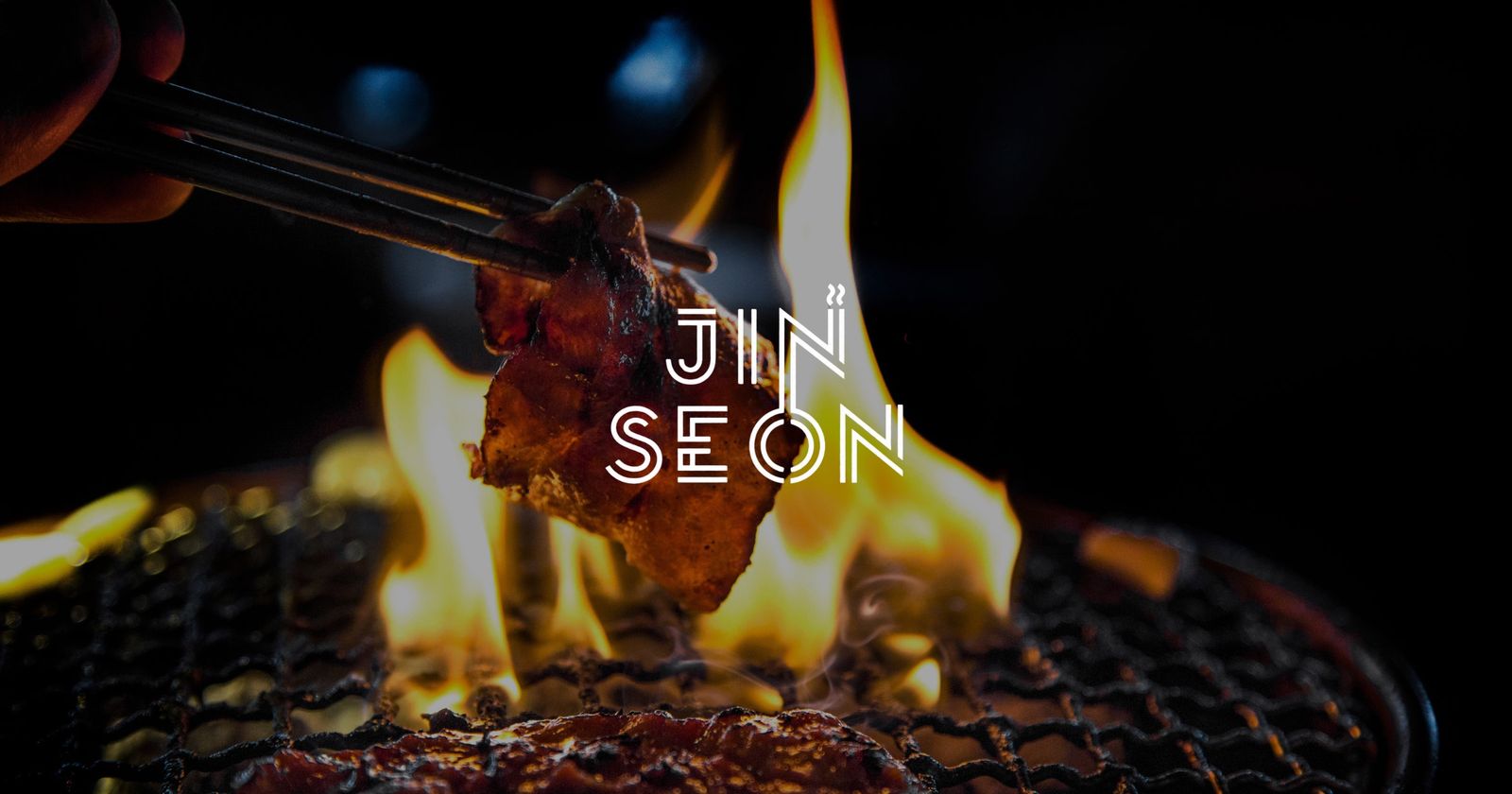 Meat lifted with chopsticks over an open charcoal flame, with the Jinseon wordmark