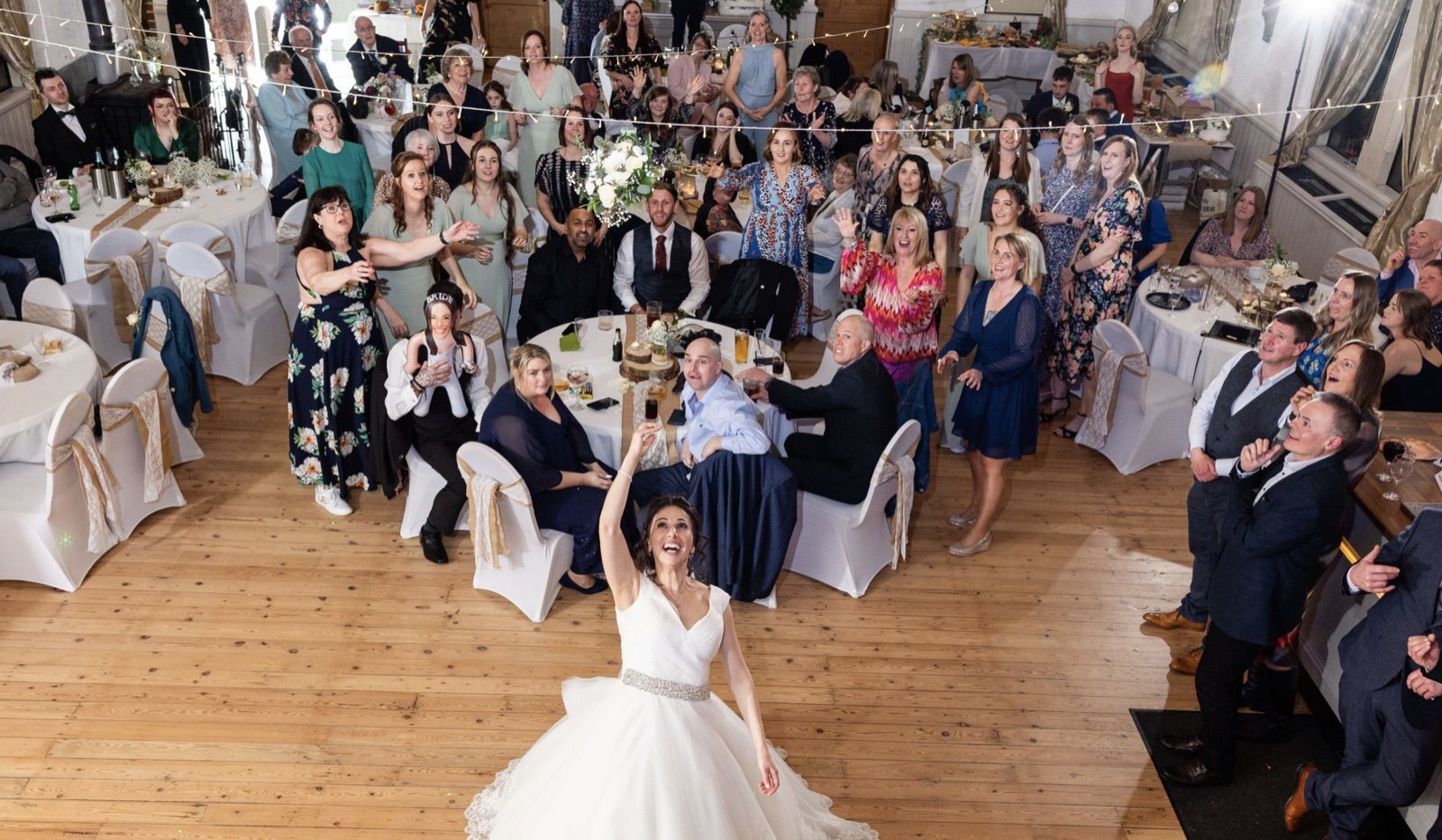 A bride and her guests celebrating at a wedding reception in the hall